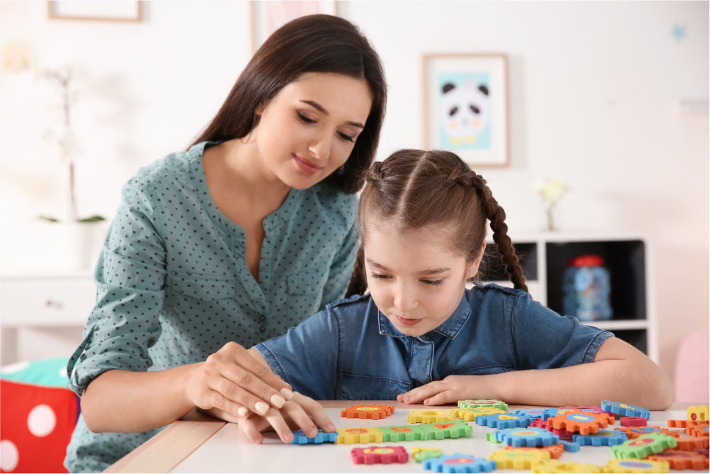 Woman guides girl as she puts puzzle together