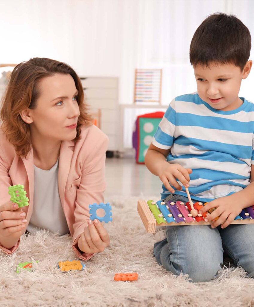 Woman and boy sit on floor and talk