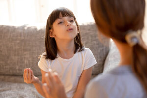 Woman works with child as they explore autism speech therapy techniques