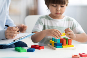 Child showing early signs of autism plays with blocks