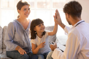 Girl high fives a therapist while celebrating ABA therapy milestones