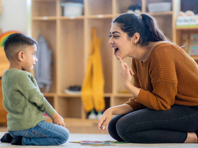 Therapist teaching boy with speech therapy