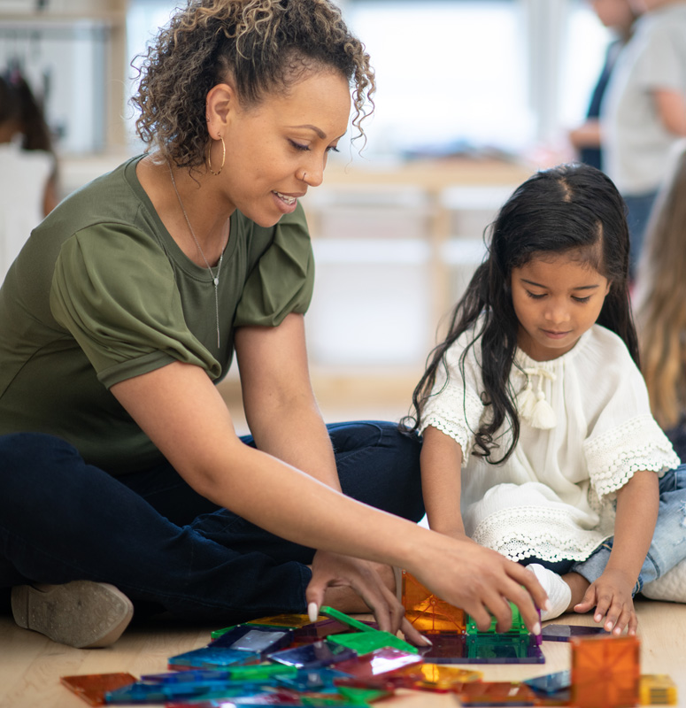 Woman and child share a moment while playing with brain teaser toys