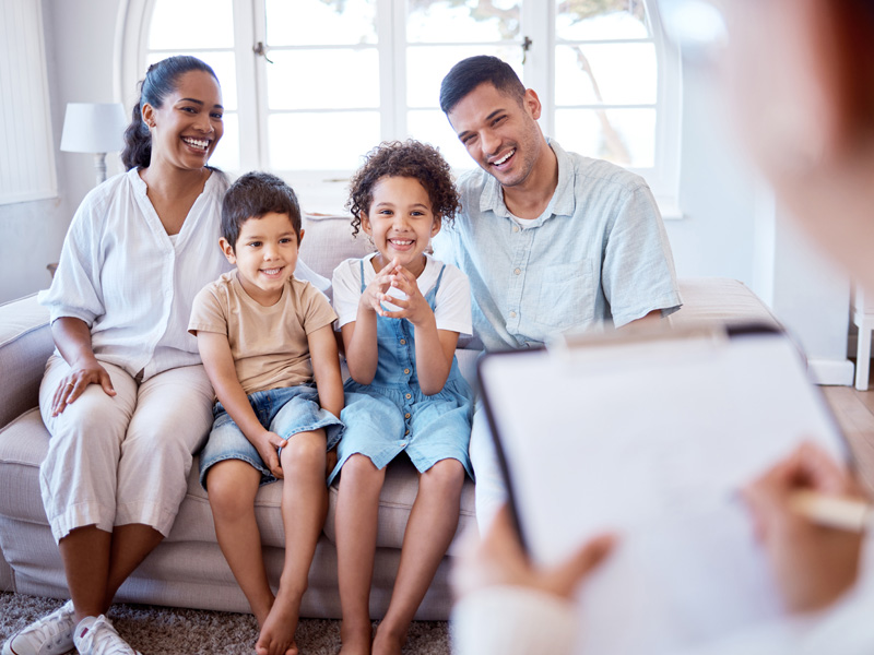 Family smiles while talking to health professional