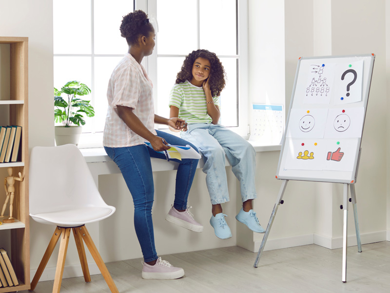 Therapist working with young patient using whiteboard