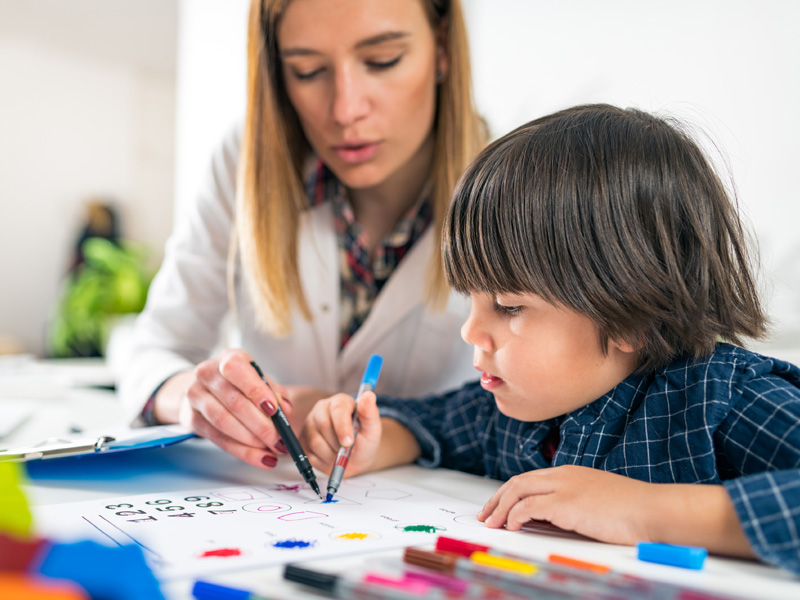 Therapist using markers with boy patient