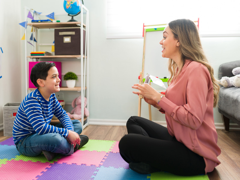 Specialist helping young boy with occupational therapy