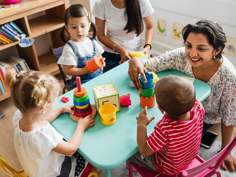 Specialist working with multiple child patients at table