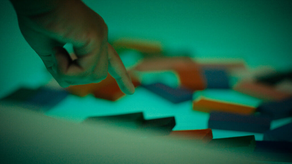 Hand pointing to illuminated blocks.
