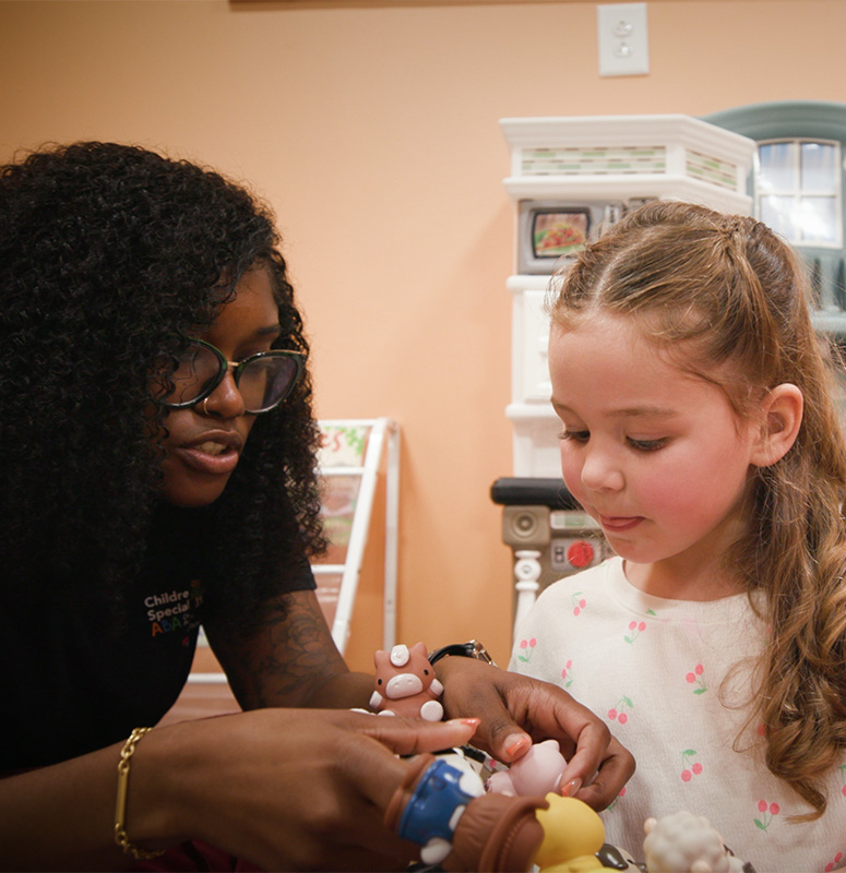 Adult showing child finger puppets.