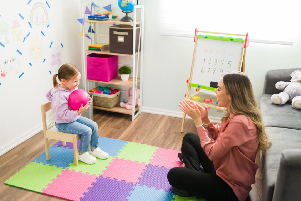 Woman giving therapy session to seated child