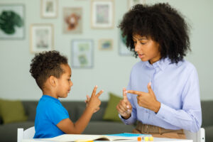 Little boy and woman communicating while sitting at table