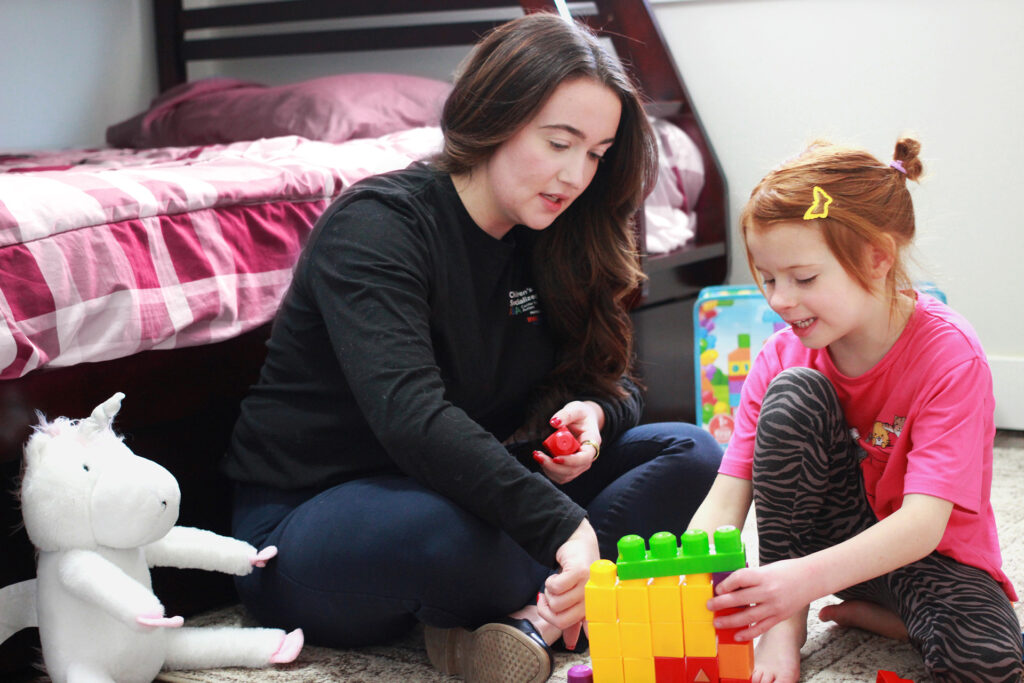 BCBA working with child on fine motor skills during in-home ABA therapy session in New Jersey
