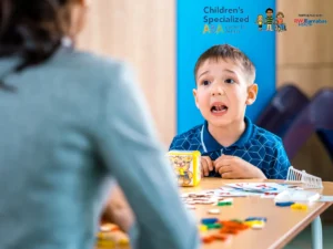 Child practicing speech and learning activities with ABA therapist at a table