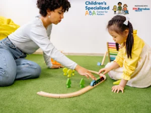 Therapist and child playing with a train set