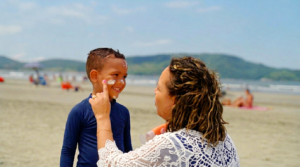 Applying sunscreen to a child, promoting sun safety for ABA therapy and summer activities.