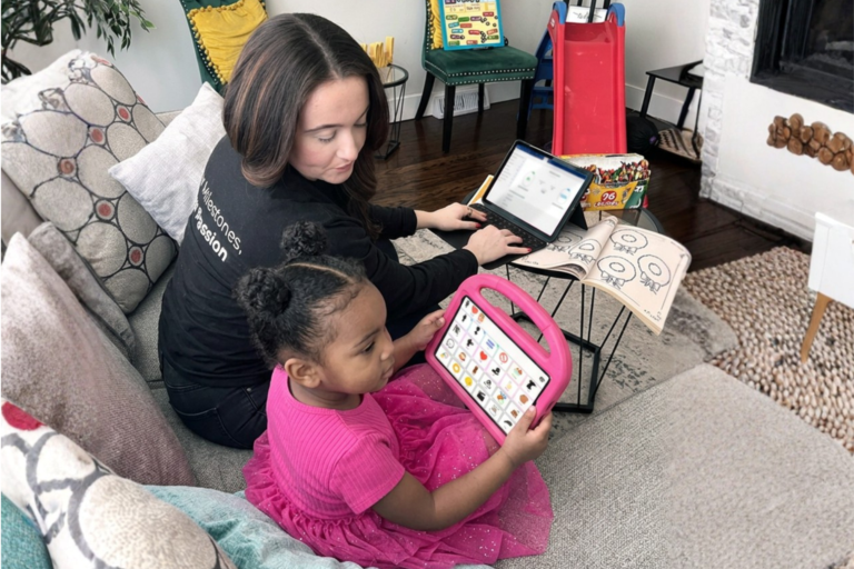BCBA works with a child using an AAC device during in home ABA session