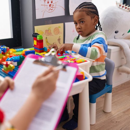 African american boy playing with construction blocks having psy