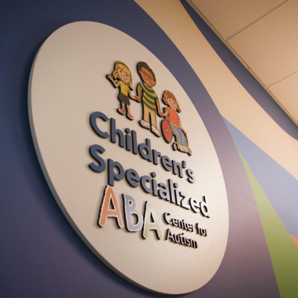Image of a sign in an office that reads 'Children's Specialized ABA Center for Autism'.